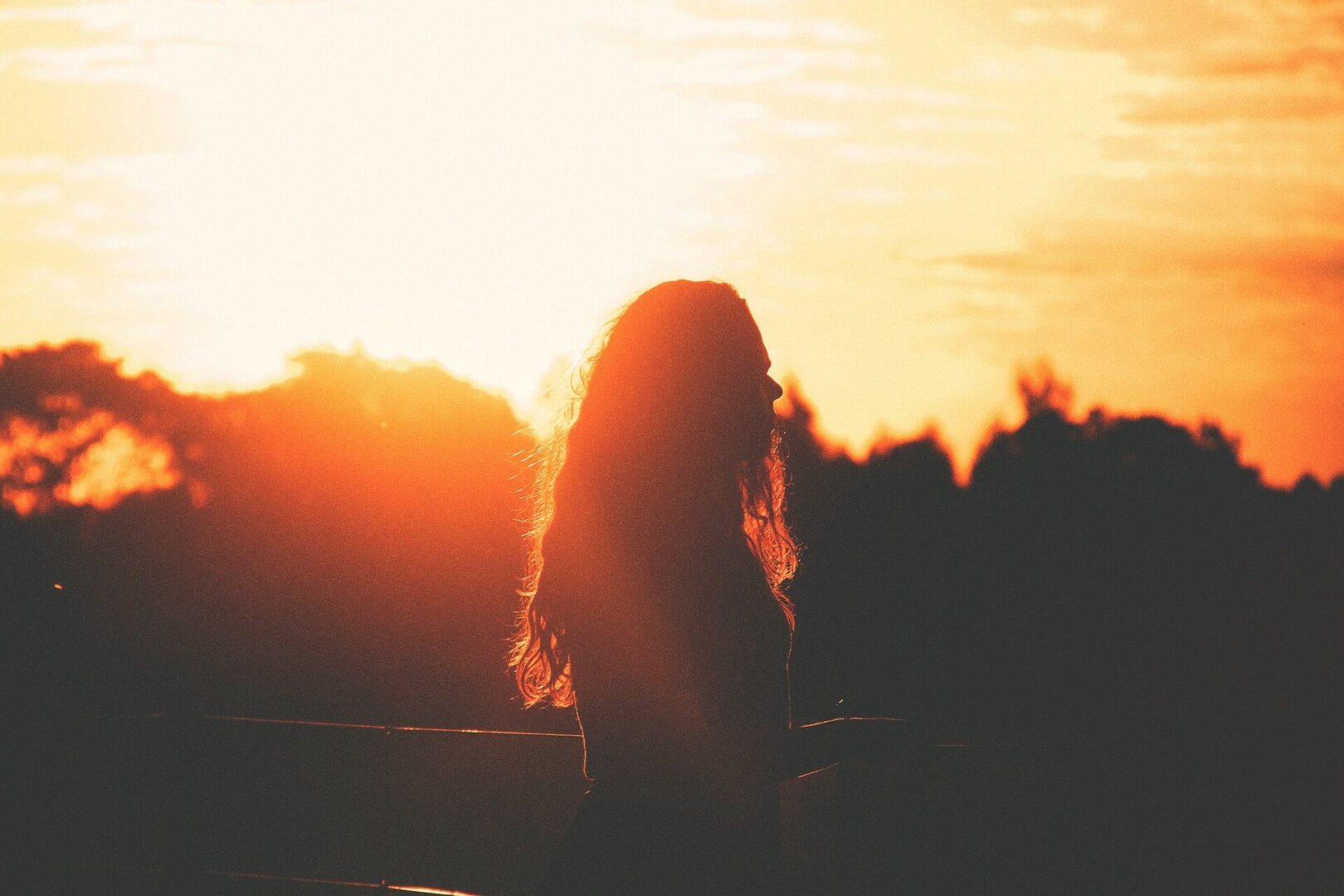 Sunset view with a woman standing with long hairs